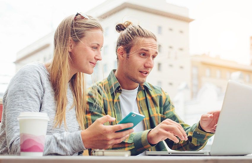 Couple de jeune gens se questionnant devant un ordinateur, carte de séjour talent